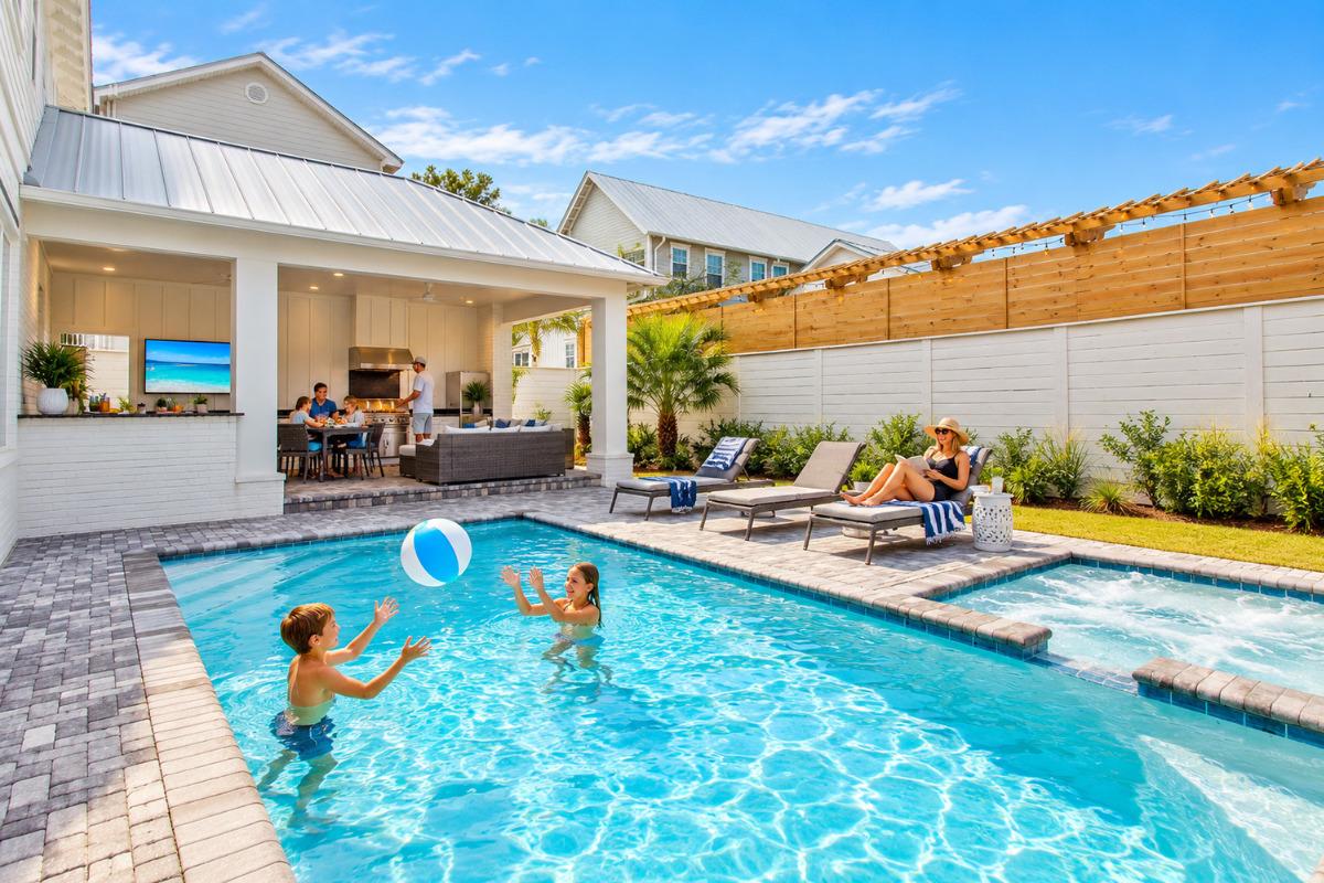 SeaStone 30A vacation home with private pool, hot tub, outdoor kitchen, and family enjoying the backyard near Gulfview Heights Beach.